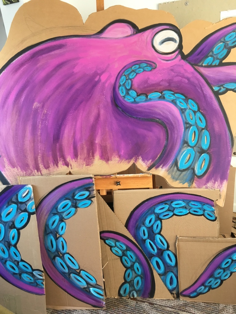 paintings on cardboard of a purple octopus and its tentacles